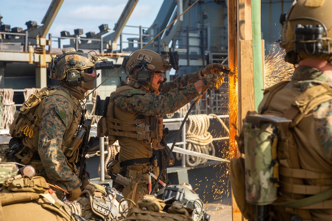 A Marine with the 31st Marine Expeditionary Unit’s Maritime Raid Force uses a cutting torch to conduct a breach during a visit, board, search and seizure full mission profile aboard the Whidbey Island-class dock landing ship USS Germantown (LSD 42).