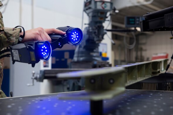 U.S. Air Force Tech. Sgt. Kevin Collins, 366th Maintenance Squadron aircraft metals technology section chief and U.S. Air Force Airman 1st Class Luke Haener, 366th MXS aircraft metals technology craftsman stand in front of a metal cutting or CNC machine, March 2, 2019, at Mountain Home Air Force Base, Idaho. The HandyScan sends the 3D image to the computer that then sends it to the CNC machine. (U.S. Air Force photo by Airman Natalie Rubenak)
