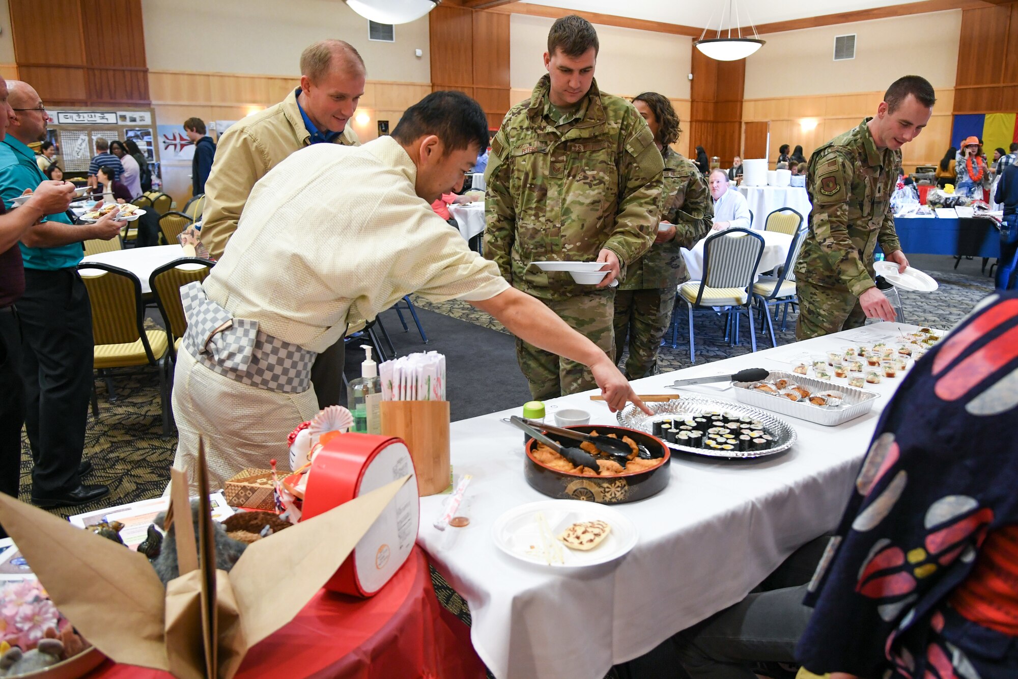 Shintaro Koya, Japan foreign liaison officer, discusses sushi with attendees at the International Culinary Tasting Buffet March 4, 2020, at Hill Air Force Base, Utah. The event was hosted by the Hill AFB foreign liaison officers and featured food, drinks, and cultural education from 15 different countries. (U.S. Air Force photo by Cynthia Griggs)