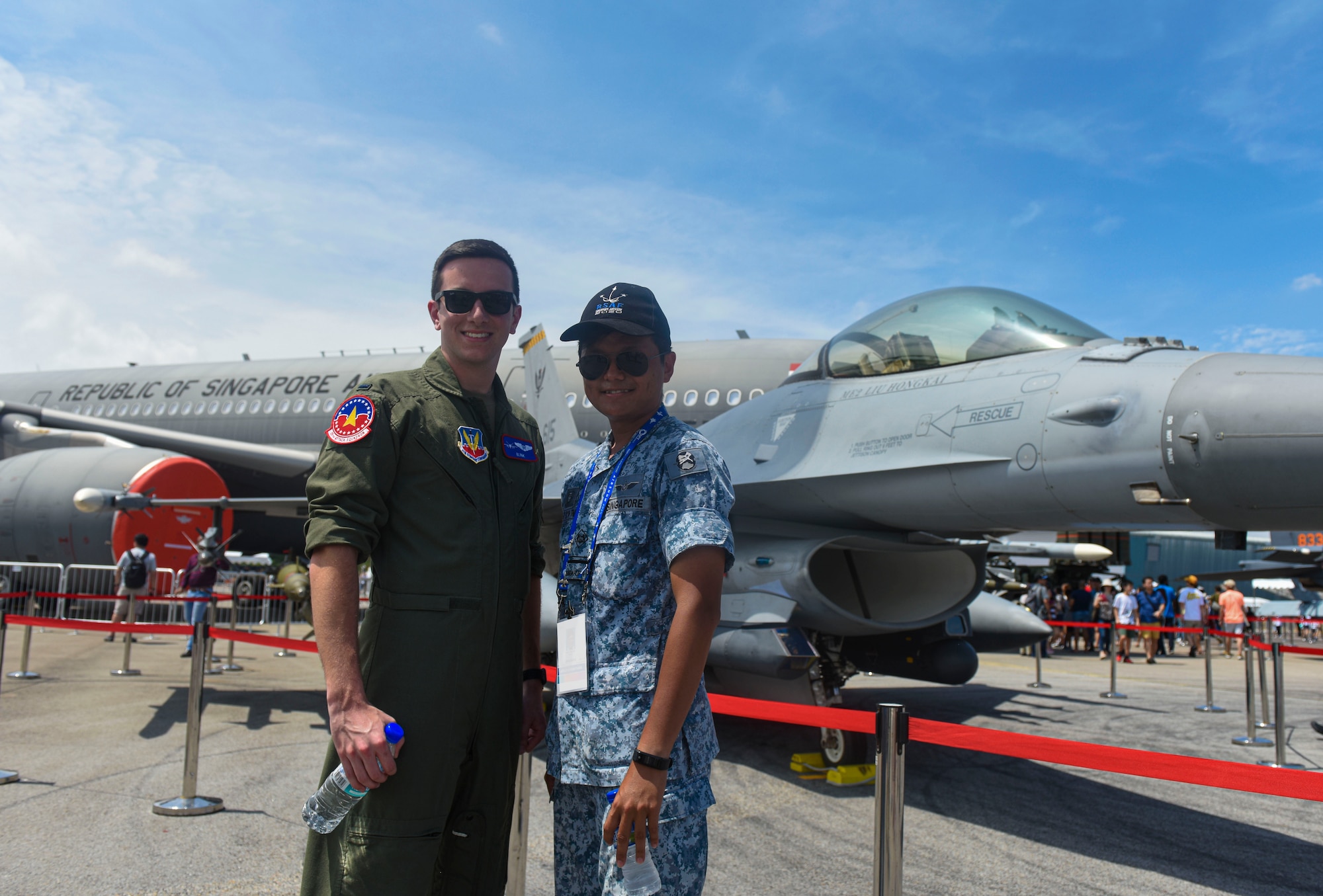 U.S. and Singapore Air Force member stand side by side smiling.