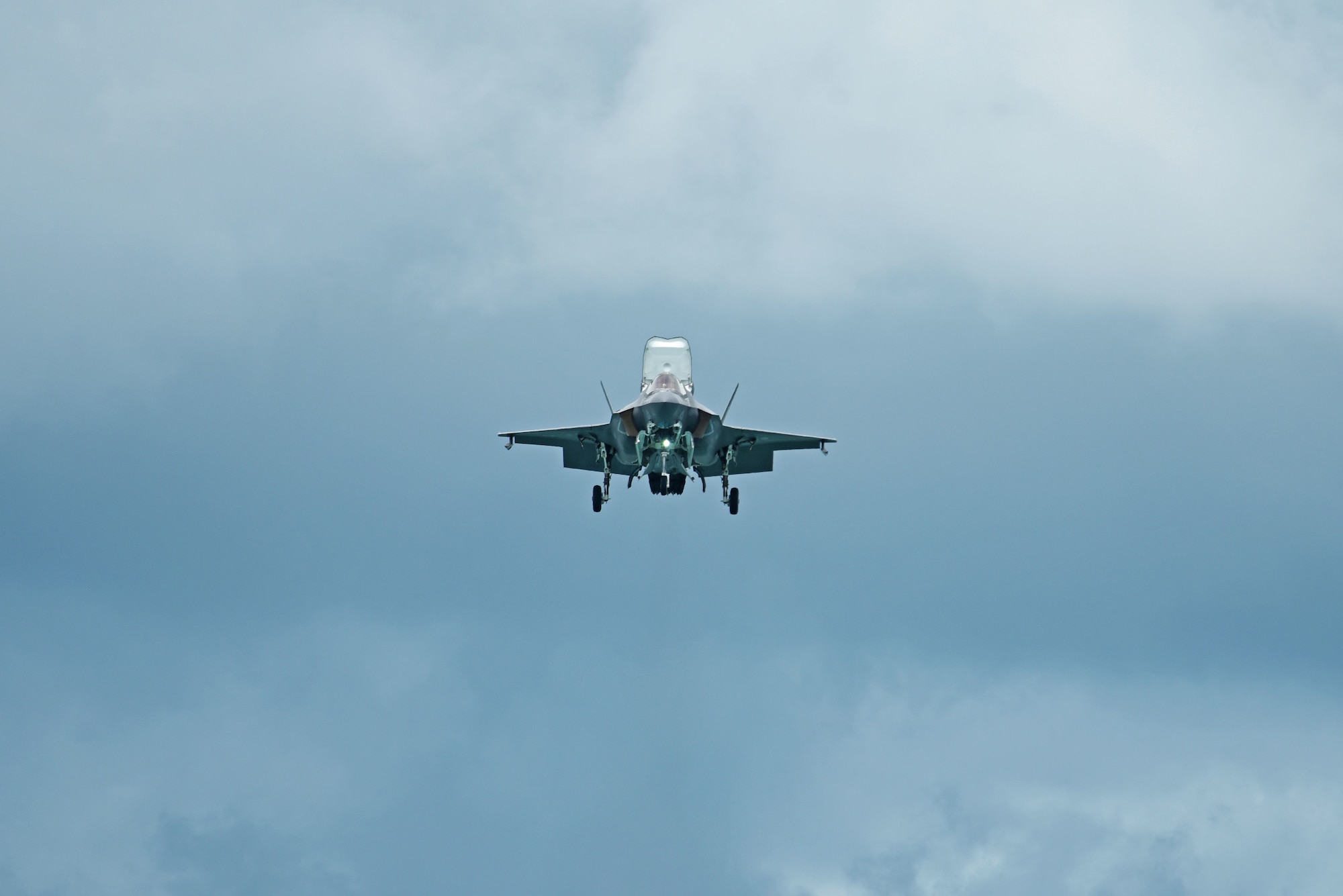 An F-35B Lightning II performs hover maneuvers at the Singapore Airshow