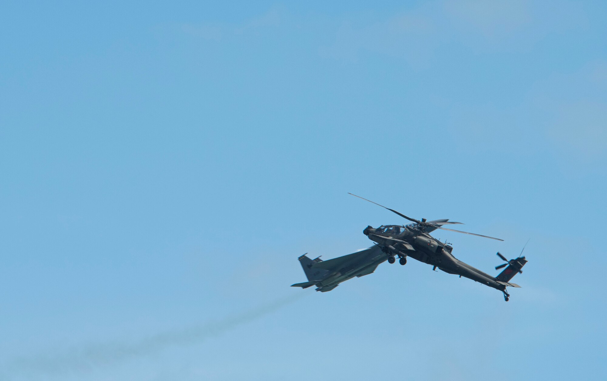 Helo and Fighter Jet cross paths during an aerial demonstration at Singapore Airshow