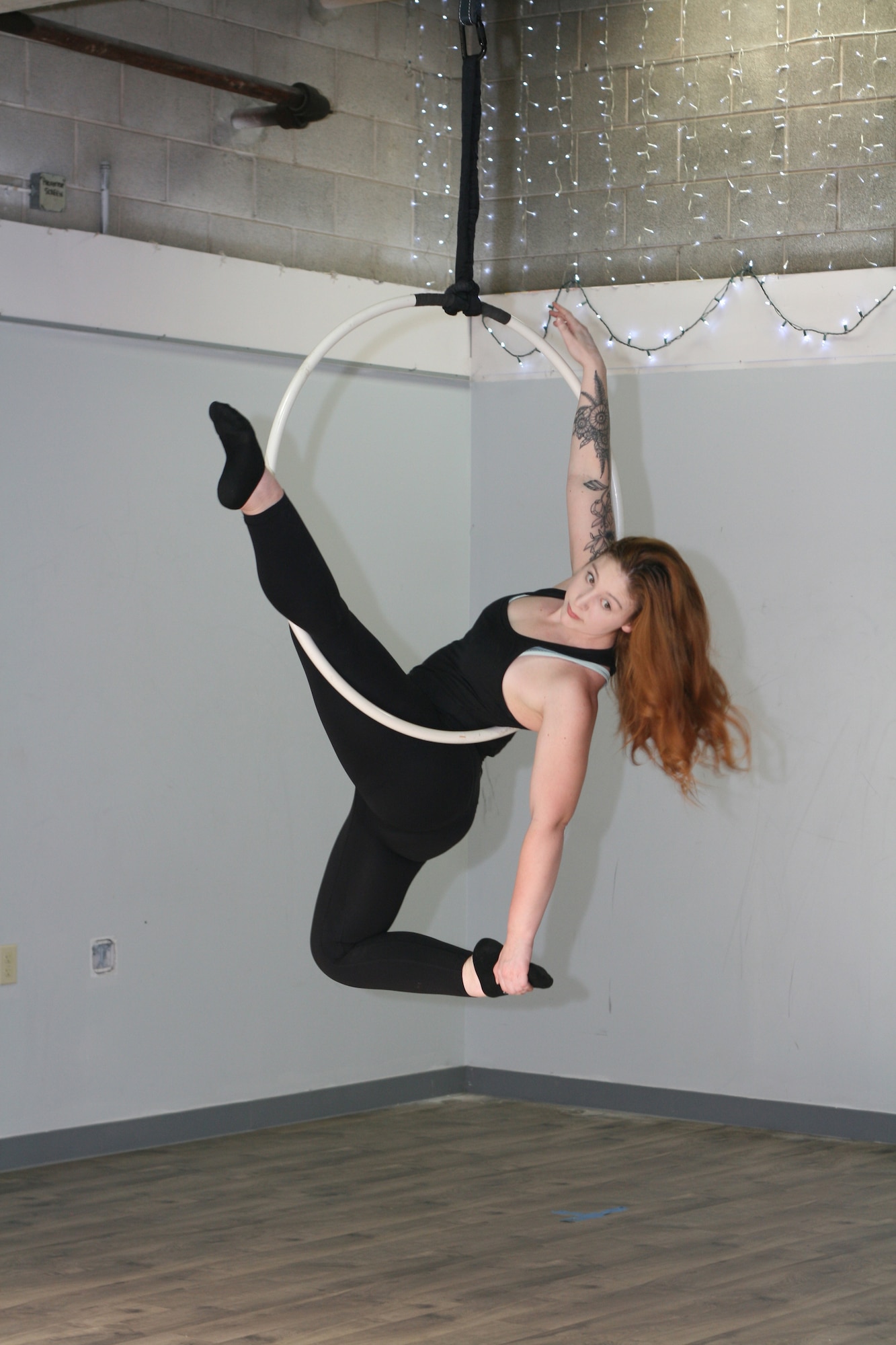 Staff Sgt. Rachel Loftis, a public affairs specialist with the 193rd Special Operations Wing, Middletown, Pa., completes a lyra workout, also known as aerial hoop - the art of performing acrobatics using a hoop connected to the ceiling. Loftis first pursued aerial acrobatics while stationed at Nellis Air Force Base, Las Vegas, which she attributes to the robust local “circus community” there and the desire to find a fitness program that was effective and held her interest. (U.S. Air National Guard photo by Tech. Sgt. Claire Forbes)