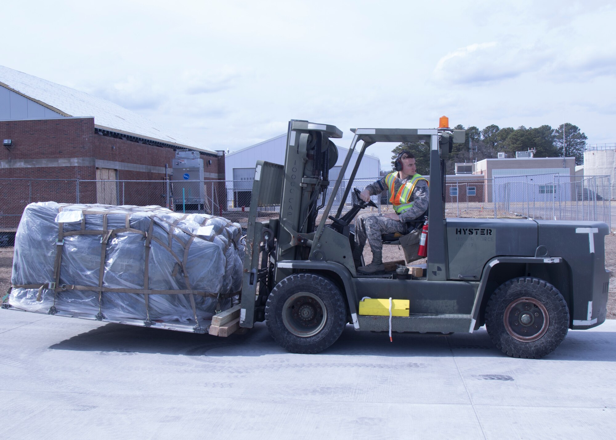 Staff Sgt. Sean Ofiara, 103rd Logistics Readiness Squadron cargo noncommissioned officer in-charge,  transports a luggage pallet to a C-130H Hercules during a large-scale readiness exercise at Bradley Air National Guard Base in East Granby, Conn. on March 3, 2020. The exercise tested the 103rd Airlift Wing’s ability to deploy to and sustain in a contested environment. Photo by U.S. Army Cpl Justin Stannard, 130th Public Affairs Detachment.