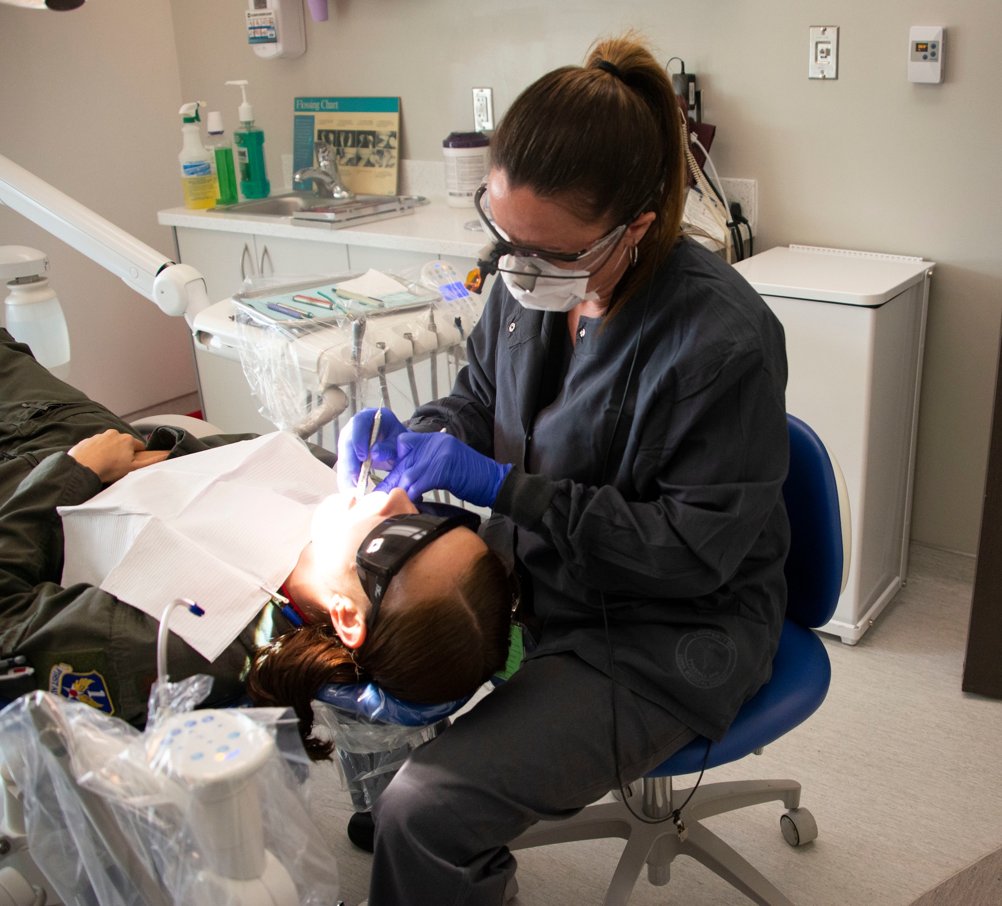 Lori Elliott, 325th Operational Medical Readiness Squadron dental technician, examines a patient at Tyndall Air Force Base, Mar. 4, 2020.  Dental assistants are recognized for the critical part they play in patient care. (U.S. Air Force photo by 2nd Lt. Kayla Fitzgerald)