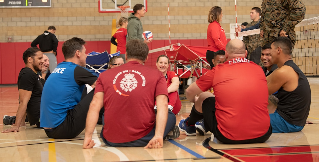 Athletes huddle during sitting volleyball practice for the 2020 Marine Corps Trials at Marine Corps Base Camp Pendleton, Calif., March 3. The Marine Corps Trials promotes recovery and rehabilitation through adaptive sport participation and develops camaraderie among recovering service members.
