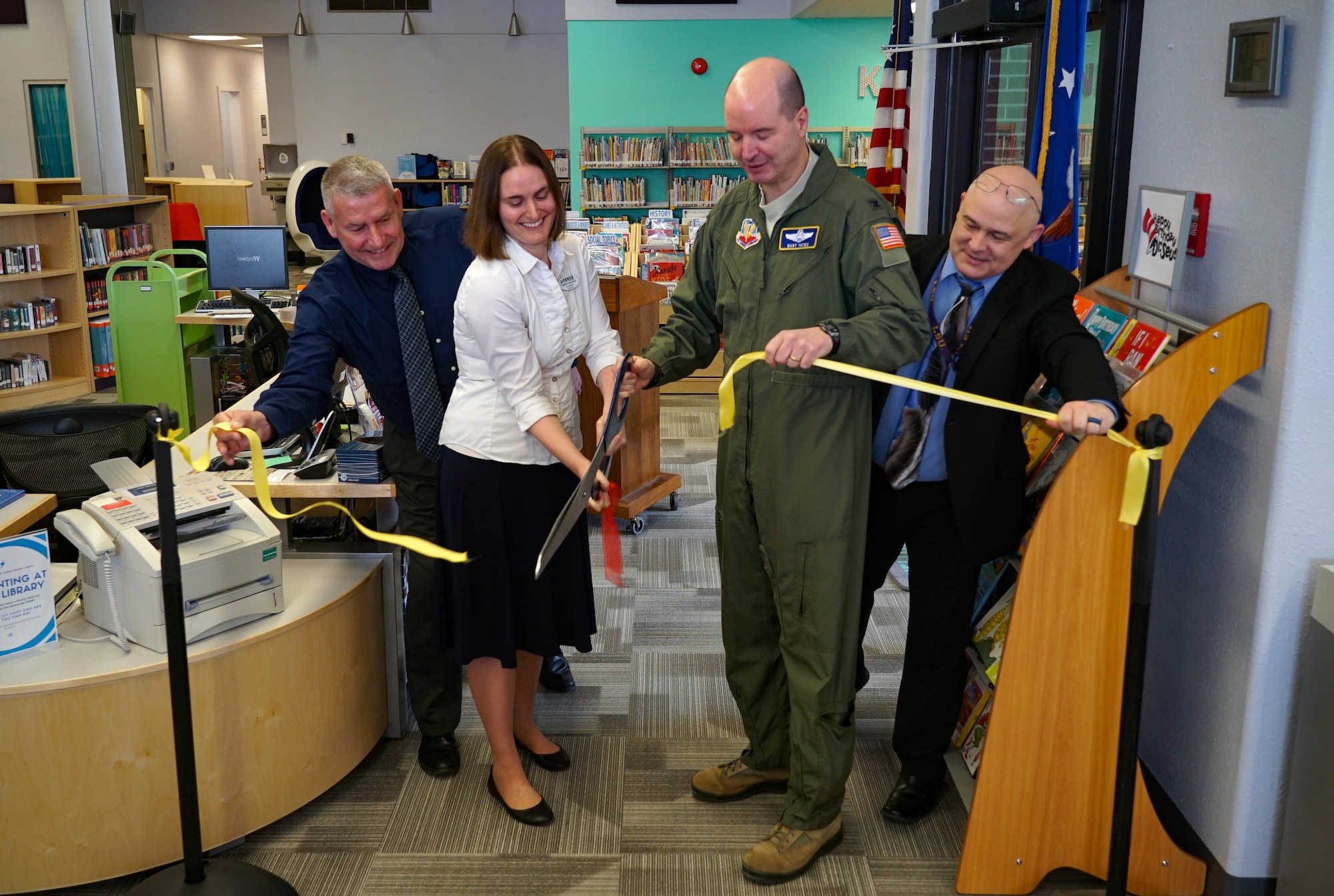 Veronica Holseth, library director, left, and Col. Bart Yates, 319th Reconnaissance Wing vice commander, right, cut a ribbon during the grand re-opening of the base library March 4, 2020, on Grand Forks Air Force Base, N.D. Base leaders, families and members of the local community joined the ceremony to celebrate the new facilities, receive a tour and participate in story time. (U.S. Air Force photo by Senior Airman Elora J. McCutcheon)