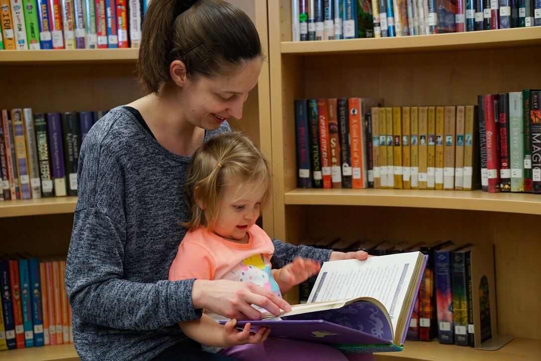 Heidi Engstrom, base resident, and her daughter, Raelynn, 18 months, read a book together following the grand re-opening of the base library March 4, 2020, on Grand Forks Air Force Base, N.D. The re-opening celebrated renovations to the library, to include new shelving, more space and better labeling and organization. (U.S. Air Force photo by Senior Airman Elora J. McCutcheon)