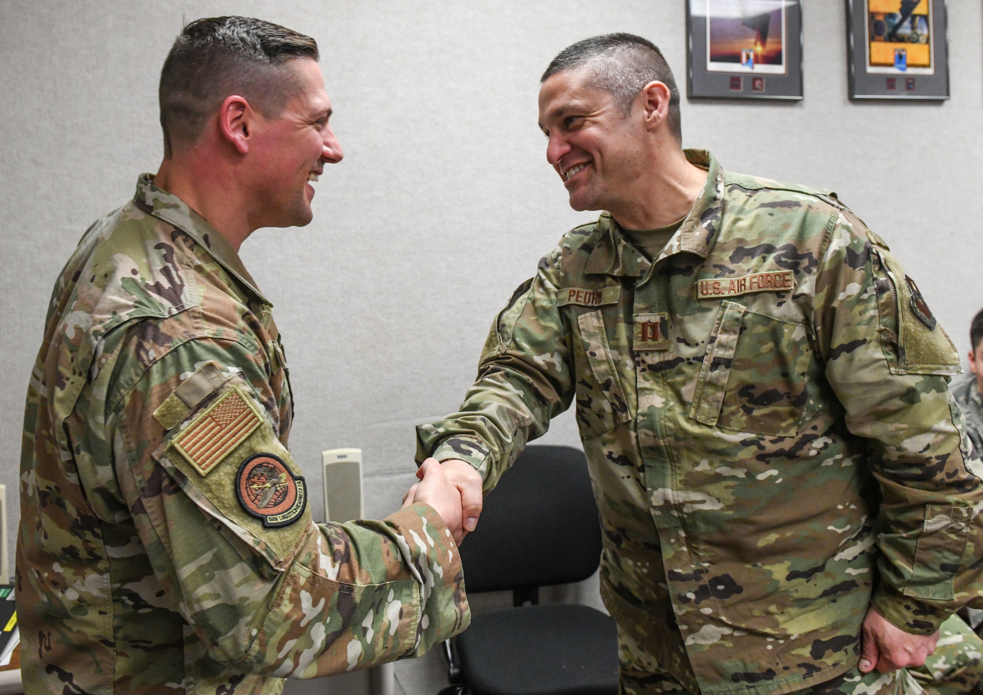 2nd Lt. Casey Bunt, left, 509th Logistics Readiness Squadron supply flight commander is coined by Capt. John Pedro III, right, the Indiana State University Detachment 218 commander, during a tour at Whiteman Air Force Base, Mo., Mar. 4, 2020. Bunt worked alongside company grade officers to coordinate an AFROTC tour to enlighten cadets on various positions they can hold within an operational Air Force base. (U.S. Air Force photo by Staff Sgt. Sadie Colbert)