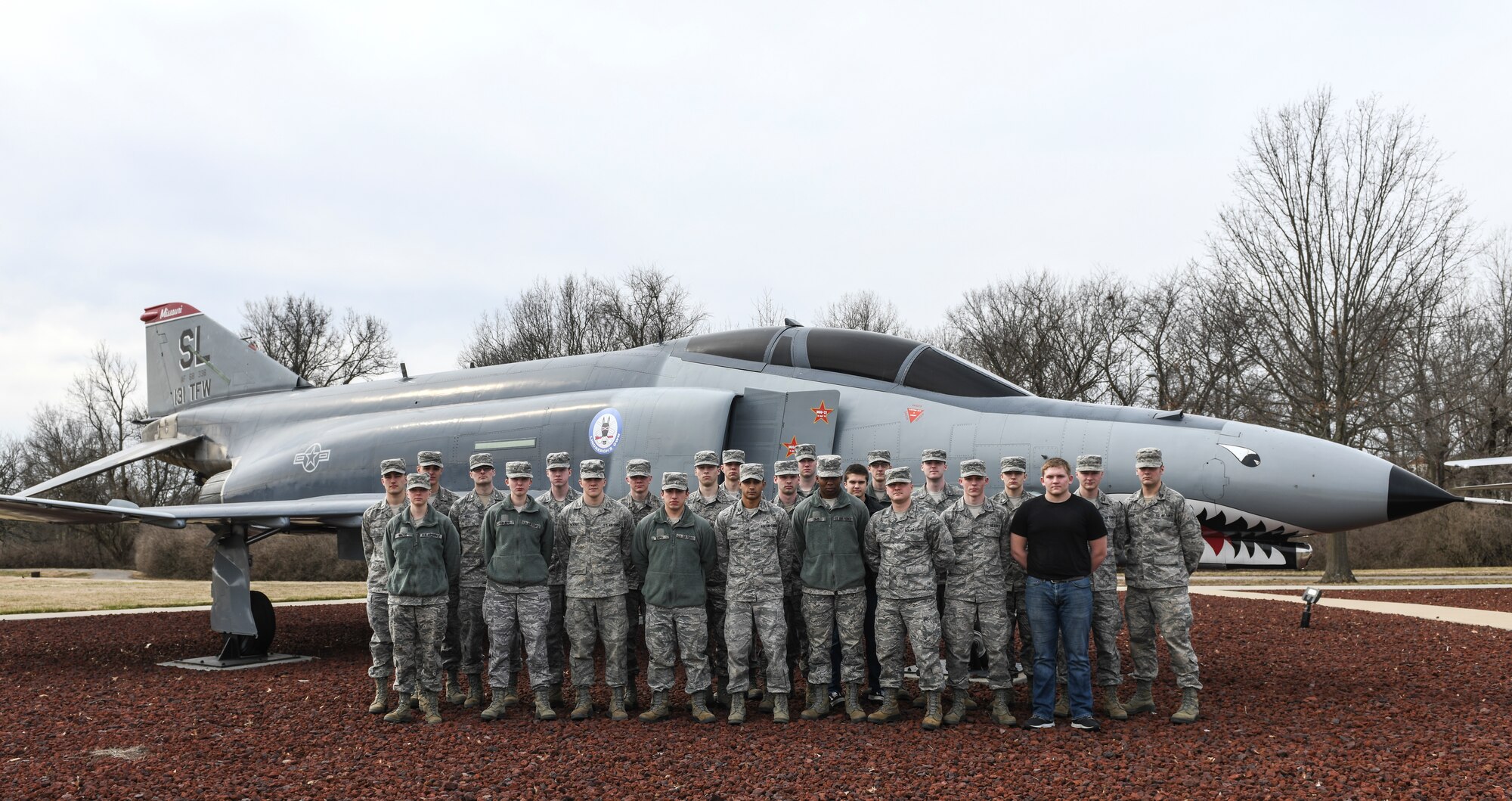 Indiana State University Detachment 218 Air Force Reserve Officer Training Corps cadets stand in front of an F-4 Phantom II static display during a tour at Whiteman Air Force Base, Mo., Mar. 4, 2020. The “Detachment 218 Phantoms” paid homage to their name by learning about the aircraft’s history in relation to WAFB. (U.S. Air Force photo by Staff Sgt. Sadie Colbert)