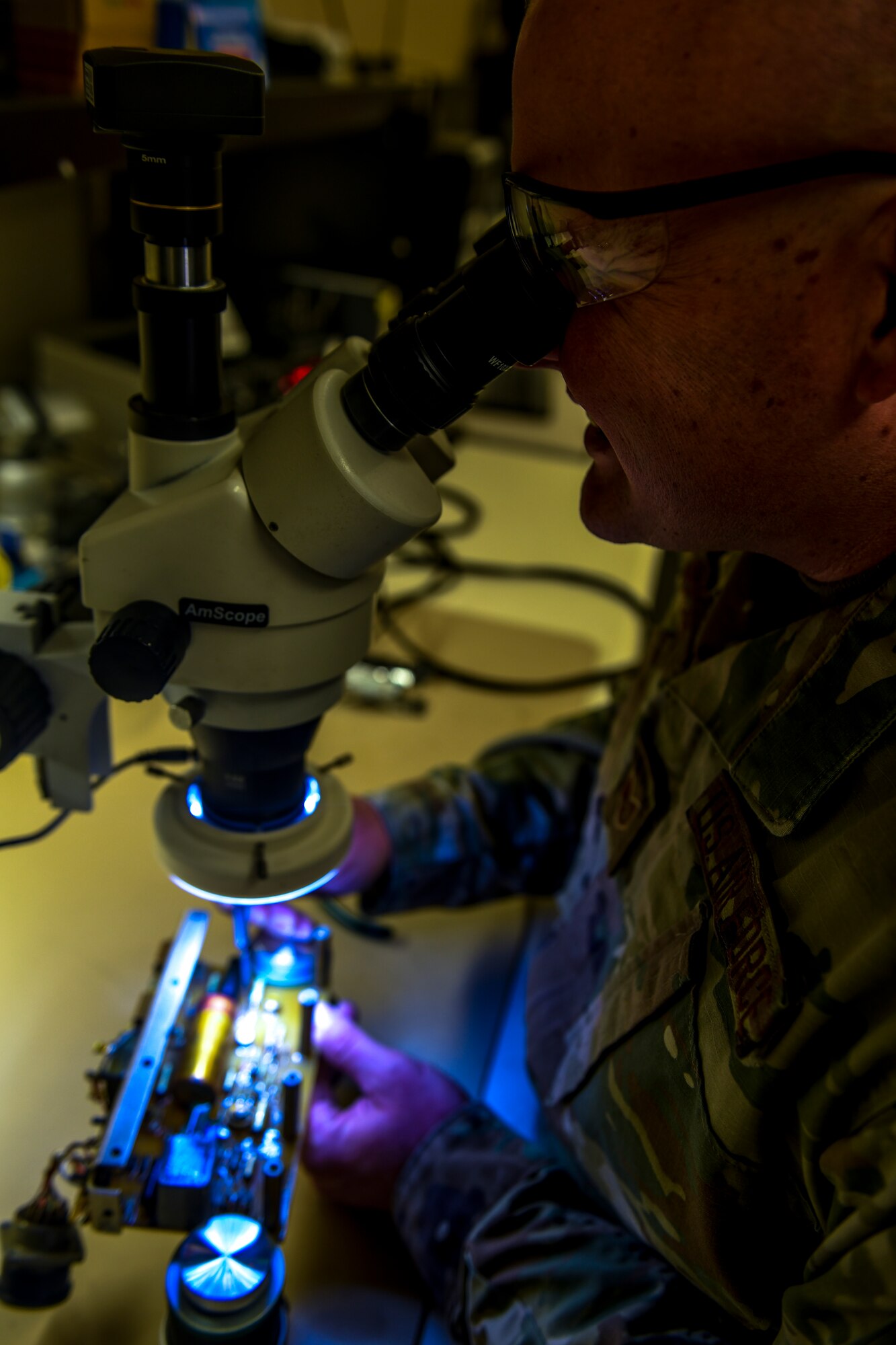 AFREP Airmen work on tiny parts that need to be magnified in order to see what they are doing.