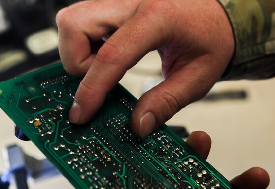 Technician touches the part that he is working on to feel for any damages at Beale Air Force Base