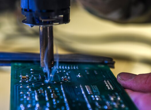 Technician, solders components on a circuit board at Beale Air Force Base.