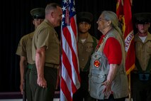 Mrs. Barbara Mathews is bestowed the title of honorary United States Marine by Maj. Gen. William M. Jurney, commanding general, 3rd Marine Division, III Marine Expeditionary Force, during an Honorary Marine ceremony, Marine Corps Base Hawaii, March 6, 2020. The Honorary Marine title is designed to reinforce the special bond between the American people and the Marine Corps by recognizing individuals in the civilian community who have made extraordinary contributions to the Marine Corps. Mrs. Mathews earn this prestigious honor for volunteering over 10 years of her personal time, talents and money capturing photo and video of hundreds of Marine Corps ceremonies, including memorials and special events surrounding the wars in Iraq and Afghanistan. (U.S. Marine Corps photo by Cpl. Matthew Kirk)