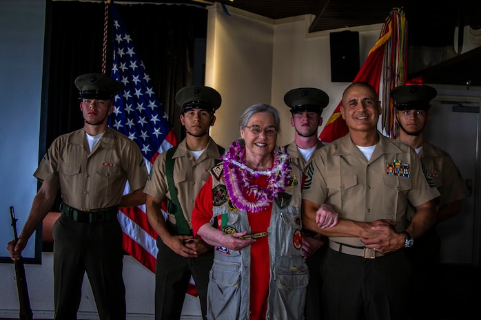 Mrs. Barbara Mathews, U.S. Marine Corps 1st Sgt. Erick Velez, Weapons Company first sergeant, 1st Battalion, 3rd Marine Regiment, and the 3rd Marine Regiment color guard pose for a group photo during an Honorary Marine ceremony, Marine Corps Base Hawaii, March 6, 2020. The Honorary Marine title is designed to reinforce the special bond between the American people and the Marine Corps by recognizing individuals in the civilian community who have made extraordinary contributions to the Marine Corps. Mrs. Mathews earns this prestigious honor for volunteering over 10 years of her personal time, talents and money capturing photo and video of hundreds of Marine Corps ceremonies, including memorials and special events surrounding the wars in Iraq and Afghanistan. (U.S. Marine Corps photo by Cpl. Matthew Kirk)