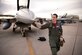 A pilot inspects the front of a jet prior to a flight.