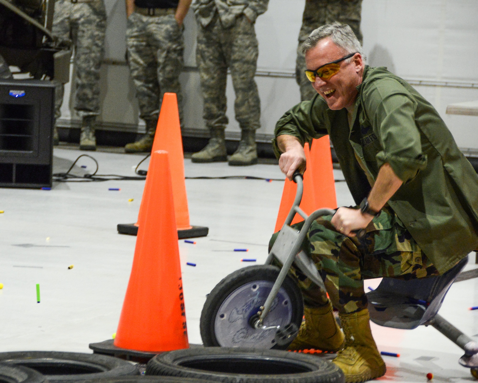 A Texas Air National Guard Colonel dismounts a tricycle on an obstacle course.