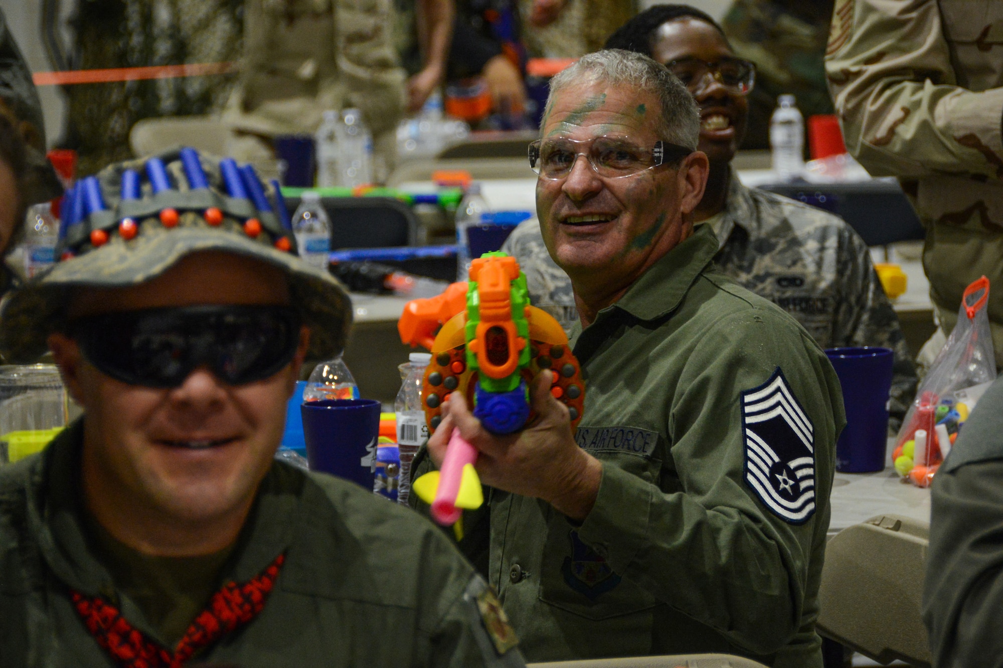 A Texas Air National Guard Chief Master Sergeant aims a foam dart gun toward the camera.