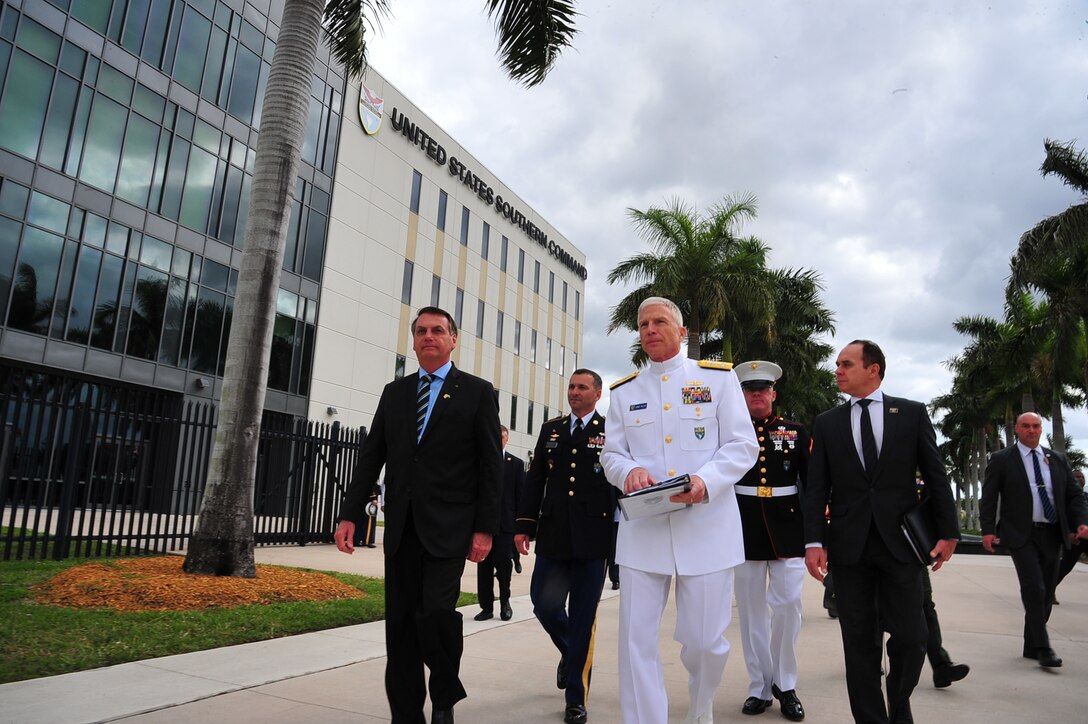 Jair Bolsonaro walks with Navy Adm. Craig Faller in Miami.