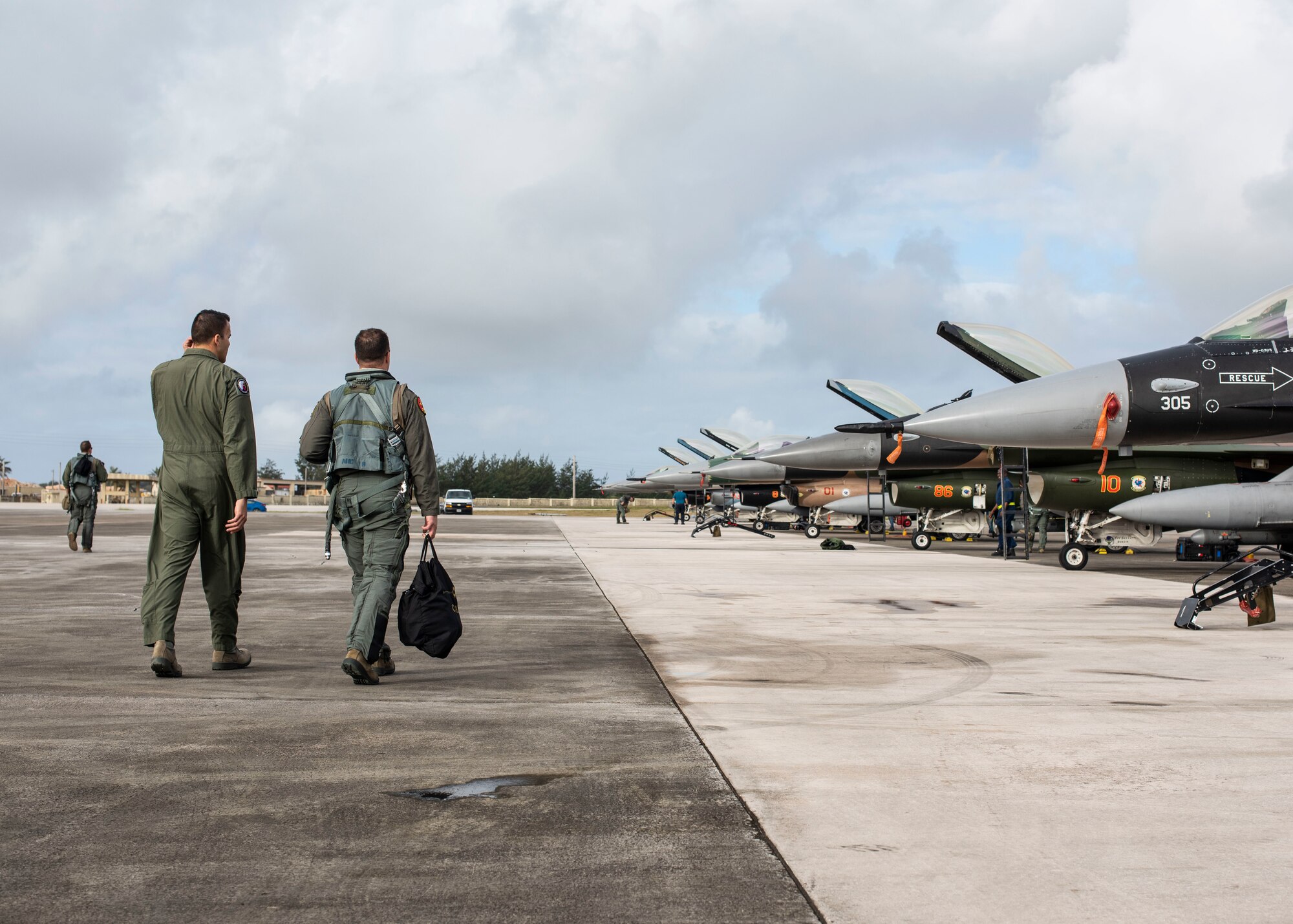 Lt. Col. Julio Rodriguez (right), an 18th Agressor Squadron pilot, and his brother Lt. Col. Antonio Rodriguez (left), a 506th Expeditionary Air Refueling Squadron pilot, walk to an F-16C Fighting Falcon February 27, 2020 at Andersen Air Force Base, Guam.