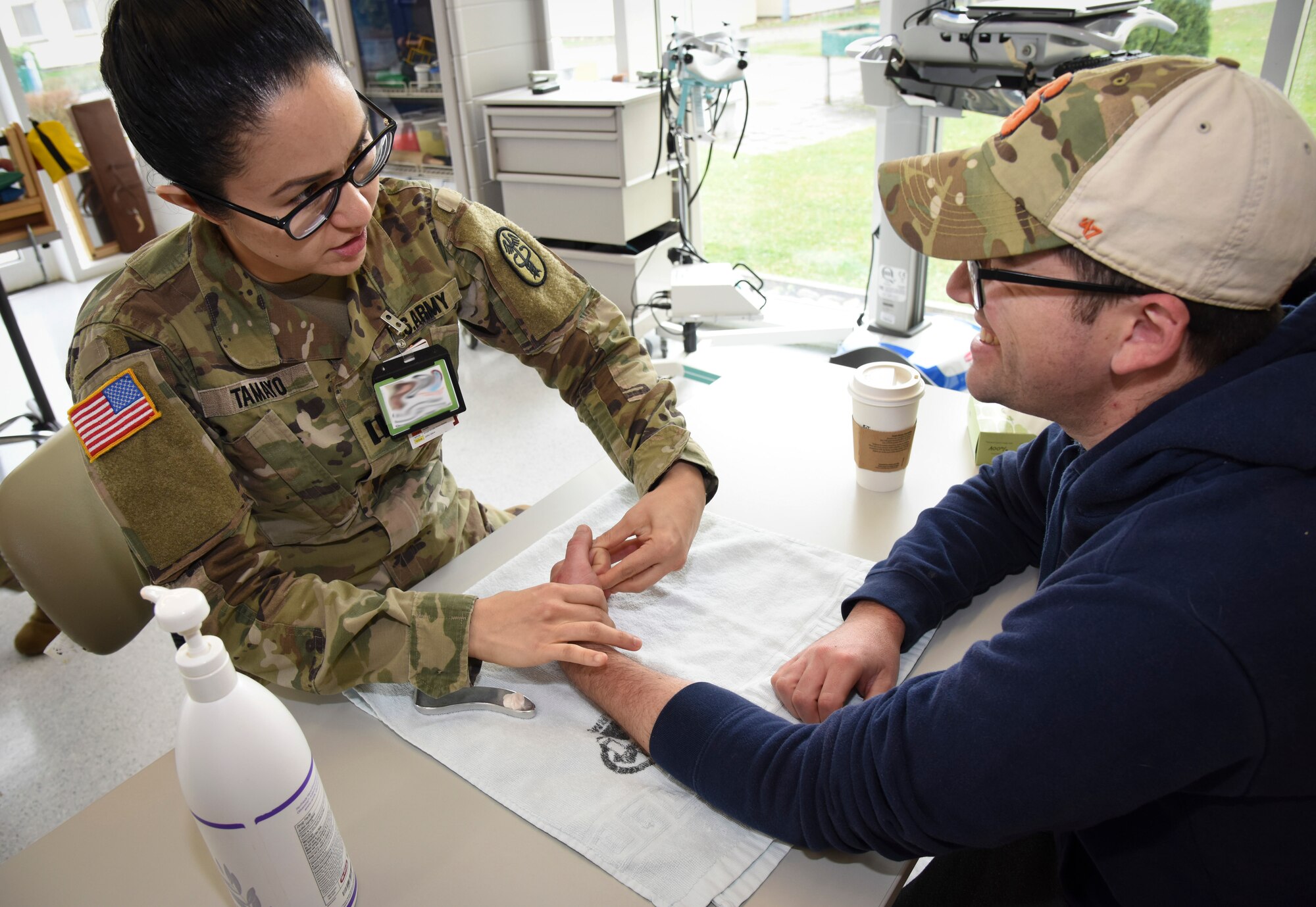 U.S. Army Capt. Jacqueline Tamayo, left, Landstuhl Regional Medical Center occupational therapy assistant chief, encourages hand flexibility for U.S. Navy Petty Officer 2nd Class Evan Parker, Armed Forces Network Europe photographer, at LRMC, Germany, March 3, 2020. Tamayo used occupational therapy techniques to help Parker recover from a hand laceration and regain flexibility, strength and motion.