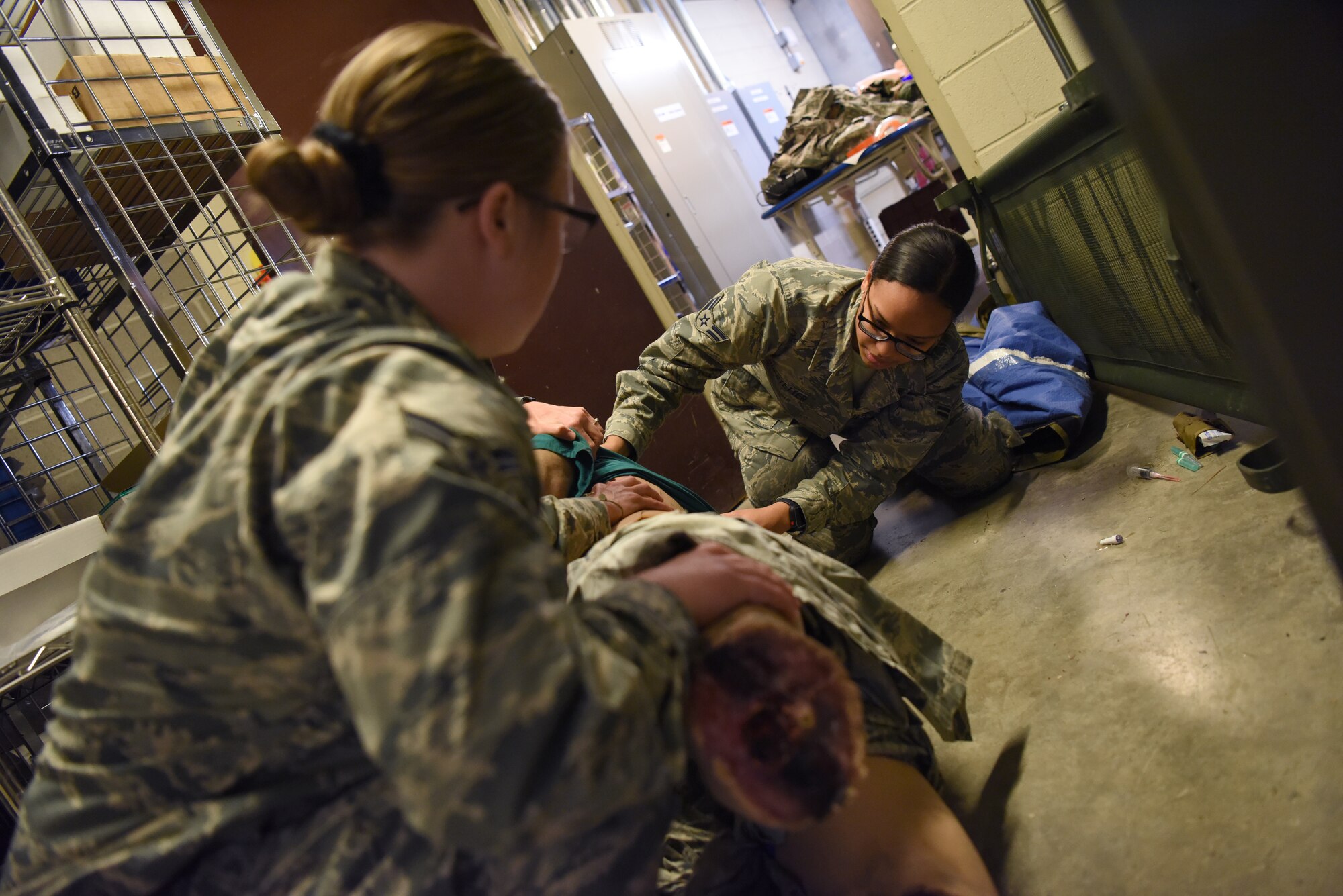 U.S. Air Force Airmen 1st Class Megan Crow, 81st Aerospace Medicine Squadron medical technician, and Alexis Hofstetter, 81st Inpatient Operations Squadron labor and delivery medical technician, check for additional wounds on a manikin during the Tactical Combat Casualty Course inside Keesler Medical Center at Keesler Air Force Base, Mississippi, Feb. 19, 2020. The TCCC is replacing self-aid and buddy care to better prepare medics for deployed environments. (U.S. Air Force photo by Senior Airman Suzie Plotnikov)