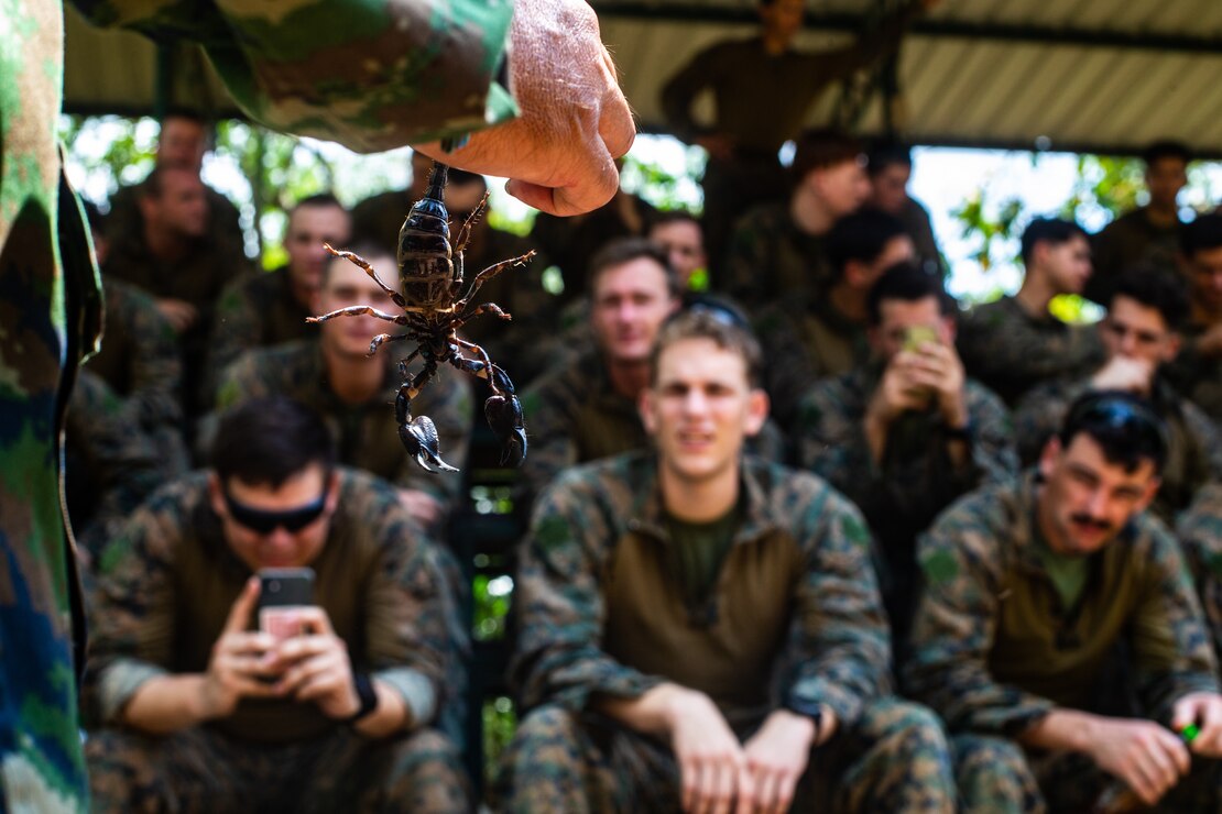A Royal Thai Marine showcases a scorpion to U.S. Marines during jungle survival training at Camp Lotawin, Kingdom of Thailand, March 4.
