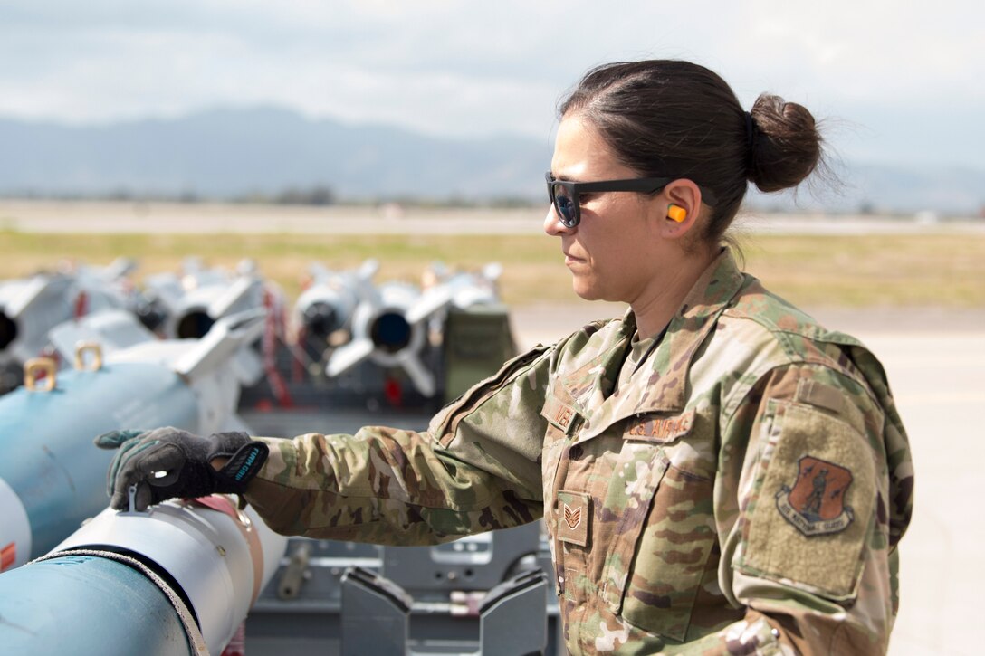 An airman looks at weaponry.