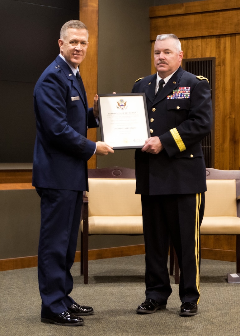 Brig. Gen. Richard Neely of Springfield, Illinois, the Adjutant General of the Illinois National Guard, presents Brig. Gen. Michael Glisson of Festus, Missouri, with his certificate of discharge from the United States Army at a retirement ceremony March 7, at the Illinois Military Academy in Springfield, Illinois.