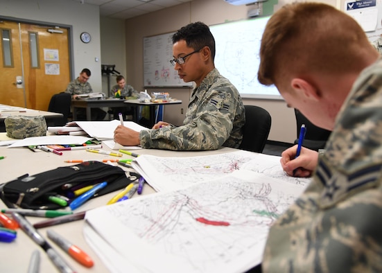 U.S. Air Force Airmen 1st Class John Sanabria and Grayson Egbert, 335th Training Squadron students, plot data on weather charts used for training inside of the the Joint Weather Training Facility at Keesler Air Force Base, Mississippi, Jan. 27, 2020. The weather apprentice course, which graduated 650 students this past year, takes 151 academic days to complete. Approximately 7,400 students go through the 335th TRS’s 13 Air Force Specialty Codes each year. (U.S. Air Force photo by Kemberly Groue)