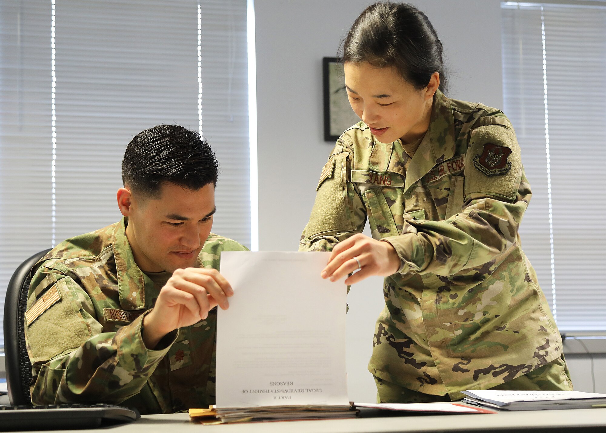 Lt. Col. Hanna Yang, 446th Airlift Wing staff judge advocate, reviews a legal file with Maj. Drew Nishiyama, 446th AW judge advocate, March 7, 2020.