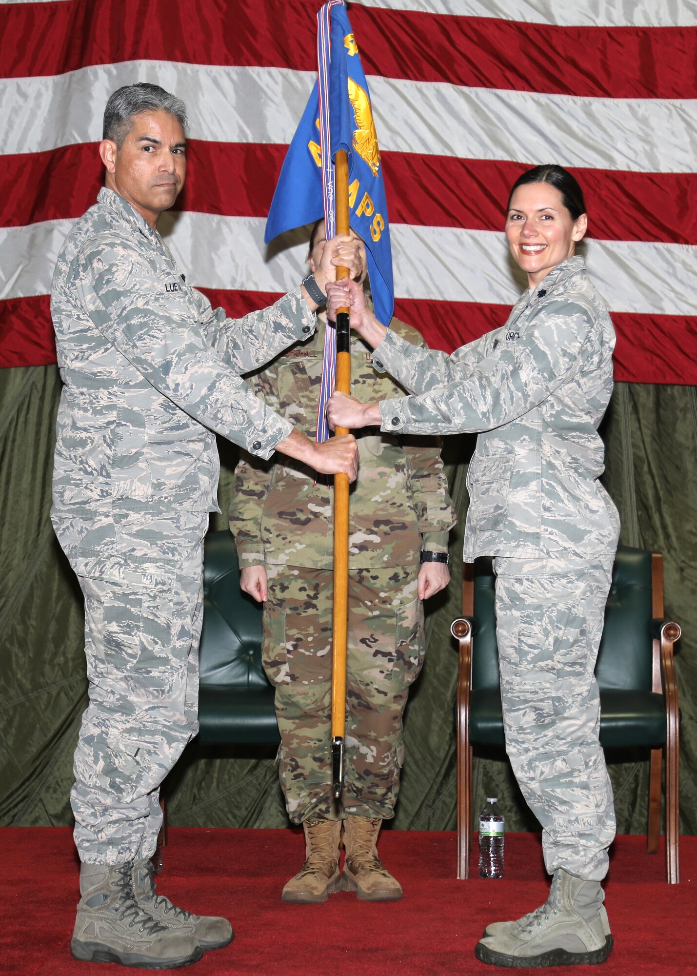 Col. Ray Luevanos, 446th Mission Support Group commander, presents the 86th Aerial Port Squadron guidon to Lt. Col. Kristi Porter, 86th Aerial Port Squadron commander, symbolizing new leadership during of a change of command ceremony March 7, 2020 on Joint Base Lewis-McChord, Washington.