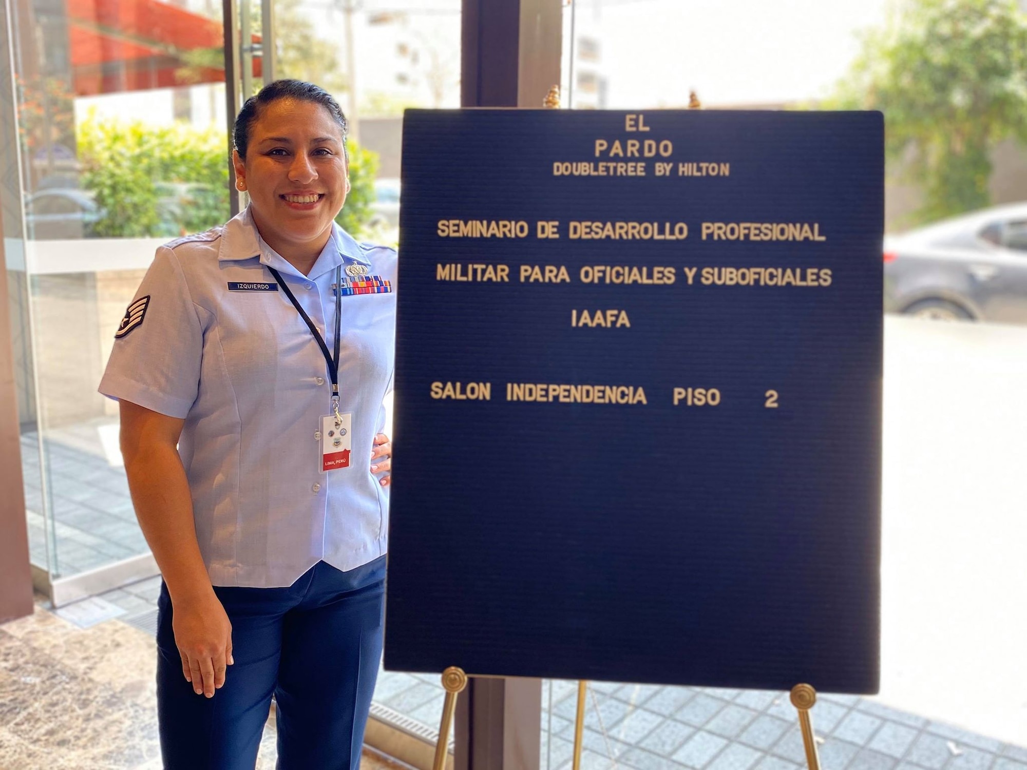 Staff Sgt. Soleine Izquierdo poses for a photo in front of the welcome sign for the second-ever Inter-American Air Force's Academy Officer and Non-commissioned Officer Professional Development Seminar in Lima, Peru, March 9. This seminar is a Joint Security Cooperation Education and Training initiative hosted by IAAFA in collaboration with the West Virginia Air National Guard and Western Hemisphere Institute for Security Cooperation.