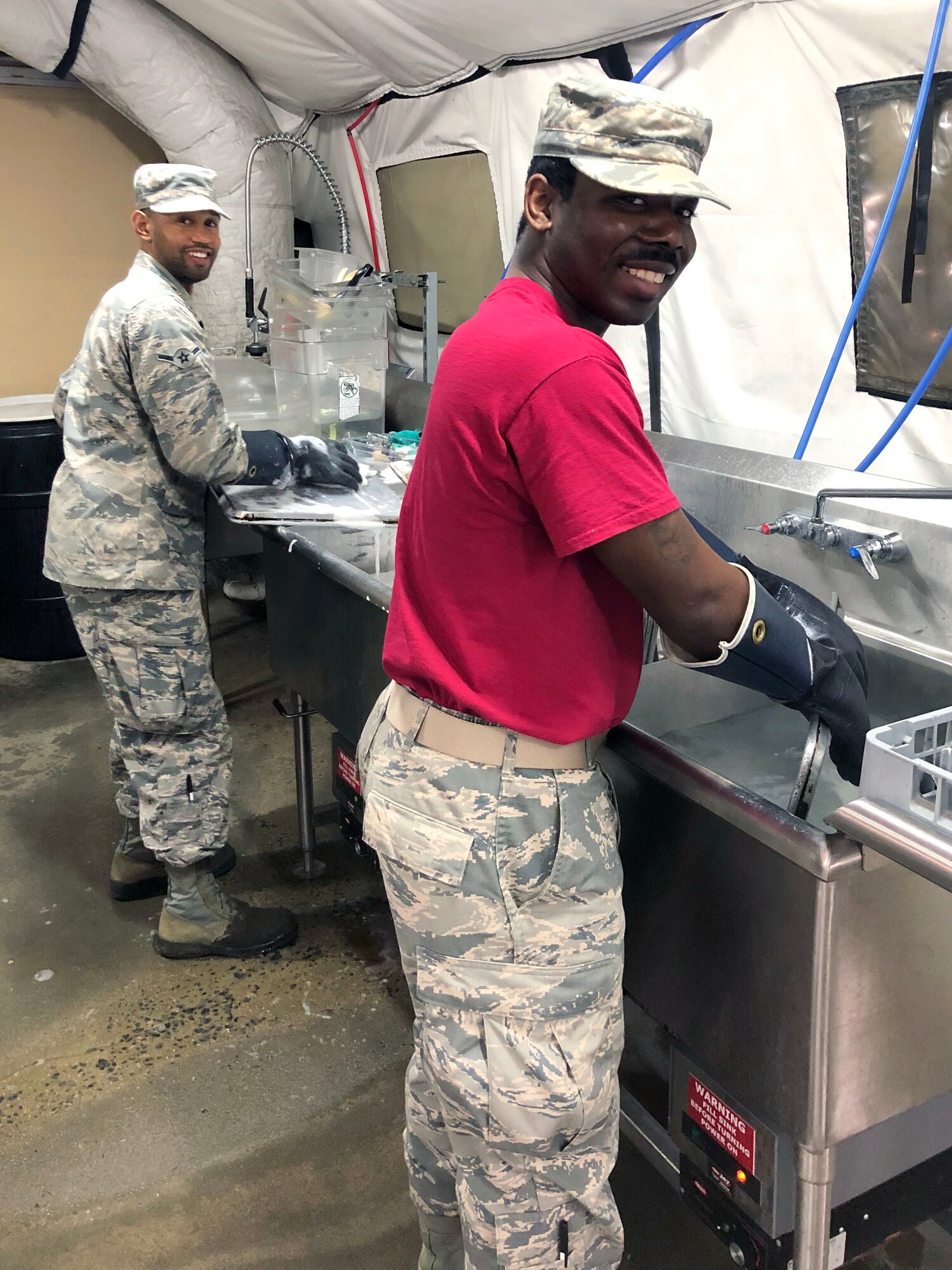 Two airmen washing dishes.