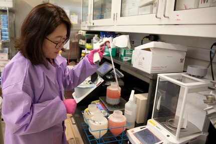 Woman fills test tube.