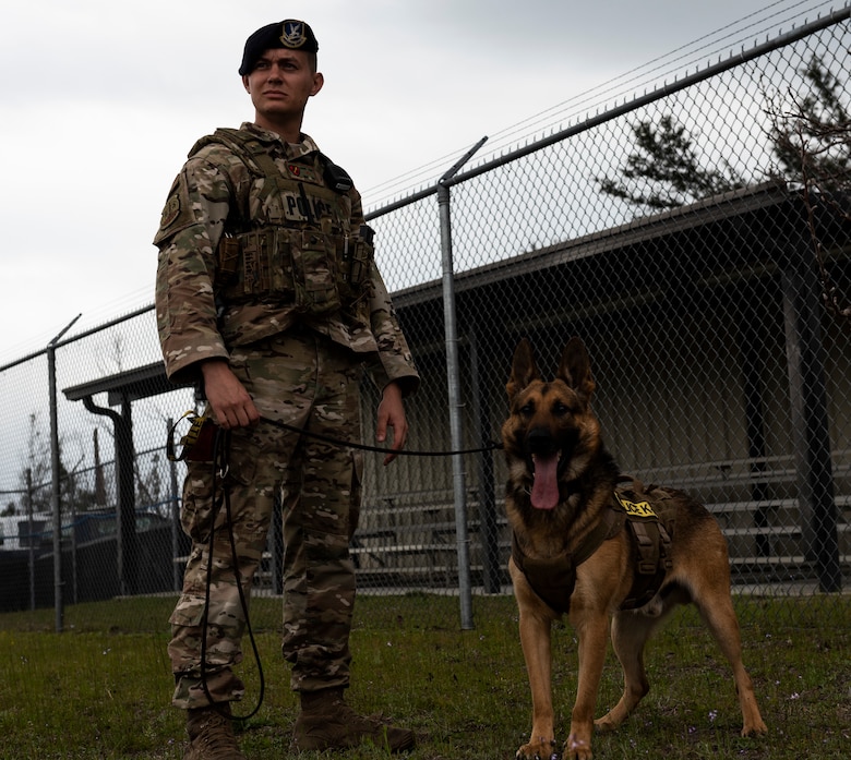 Staff Sgt. Jason Vogt, 325th Security Forces Squadron military working dog handler, and Sunny, 325th SFS MWD, pose for a photo at Tyndall Air Force Base, Florida, March 3, 2020. This photo was taken while doing a demonstration for K-9 Veterans Day. (U.S. Air Force photo by Staff Sgt. Magen M. Reeves)