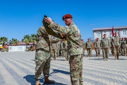 Lt. Col. David E. Moulton, commander of the 1st Squadron,112th Cavalry Regiment, Texas National Guard, and Command Sgt. Maj. Bradley A. Sutton, the 1-112th senior enlisted advisor, roll and uncase their colors to signify the start of their mission at a transfer of authority ceremony on South Camp, in Sharm el-Sheikh, Egypt, March 8, 2020. The 1-112th assumes responsibility as the 67th rotational United States Army unit in support of the Multinational Force and Observers peacekeeping mission.