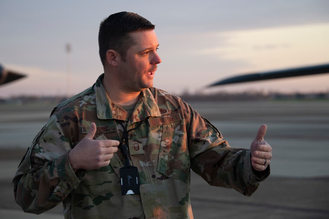 Photo of Airman gesturing on the flightline.