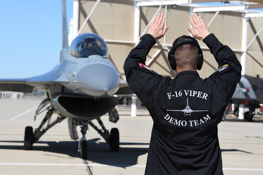 A photo of an F-16 Viper Demonstration Team member marshaling in an F-16 Fighting Falcon.