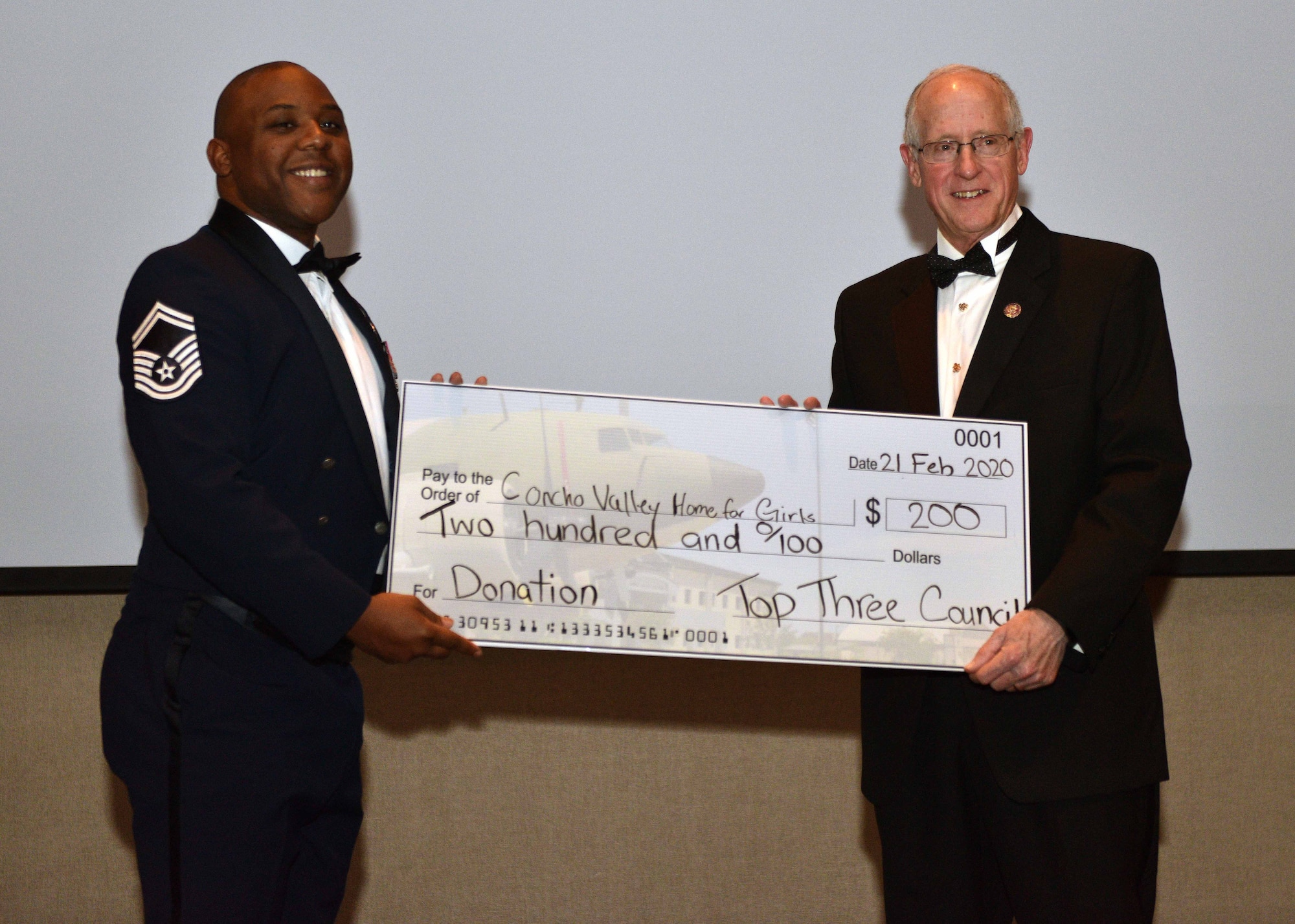 U.S. House of Representatives Congressman, Honorable Mike Conaway, is presented a check as a donation from Senior Master Sgt. Charmane Tatum, vice president of the Goodfellow Top 3, for the Concho Valley Home for Girls during the 17th Training Wing Annual Awards Ceremony at the McNeese Convention Center in San Angelo, Texas, Feb. 21, 2020. This donation was made in Conaway’s name as a thank you for speaking at the event. (U.S. Air Force photo by Airman 1st Class Robyn Hunsinger)