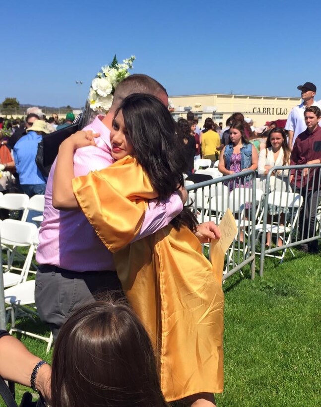 Dakotah Daniels, 17, hugs her father, Chief Master Sgt. Thomas Daniels, during her high school graduation ceremony at Cabrillo High School, Calif., in June 2015. (Courtesy photo)