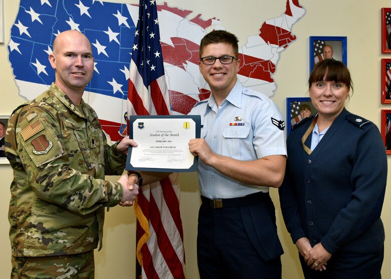 U.S. Air Force Lt. Col. Kevin Boss, 17th Training Group director of operations, presents the 316th Training Squadron Student of the Month award to Airman 1st Class Jakob Volcheck, 316th TRS student, at Brandenburg Hall on Goodfellow Air Force Base, Texas, February 6, 2020. The 316th TRS’ mission is to conduct U.S. Air Force, U.S. Army, U.S. Marine Corps, U.S. Navy and U.S. Coast Guard cryptologic, human intelligence and military training. (U.S. Air Force photo by Airman 1st Class Robyn Hunsinger)