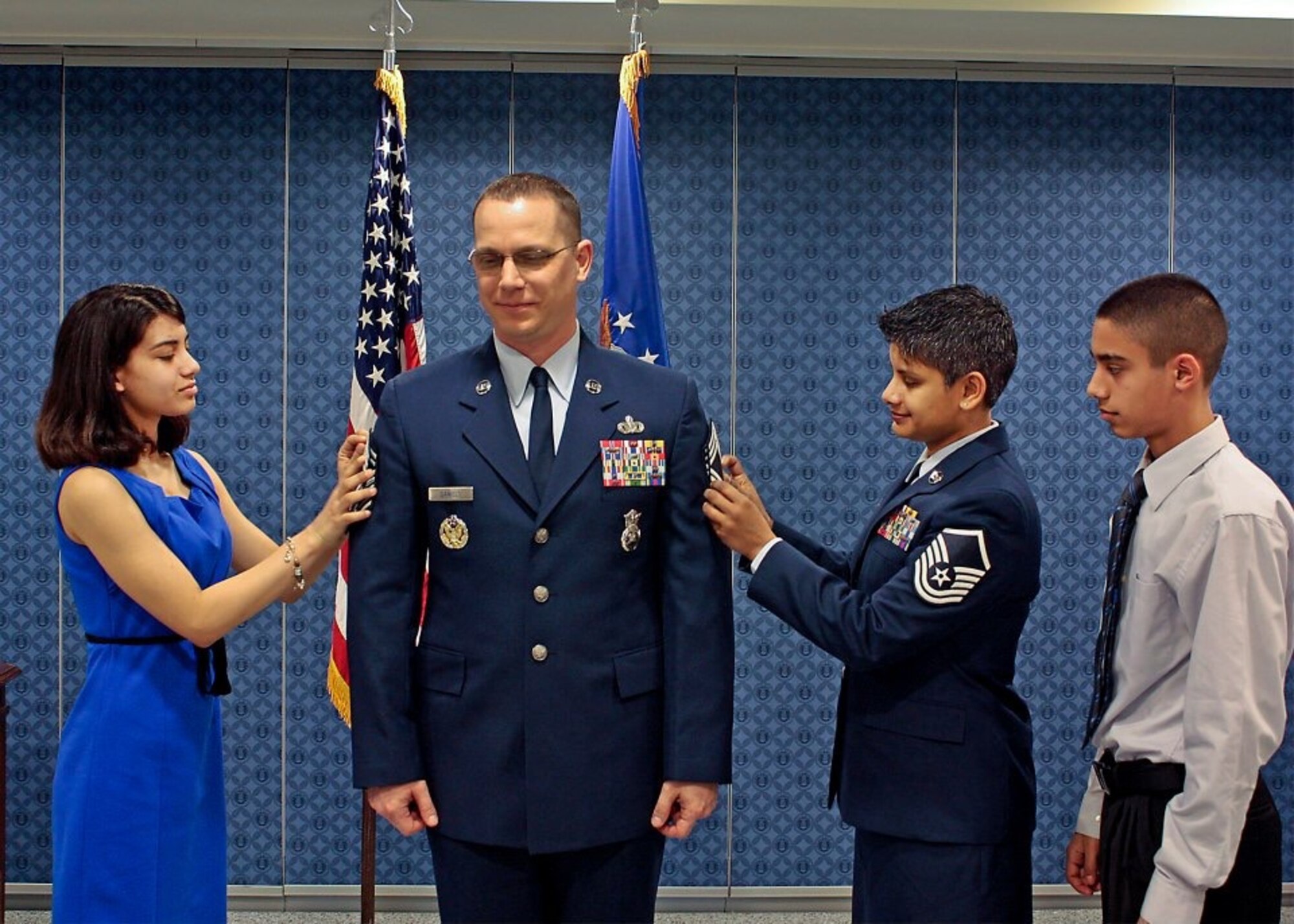 Then-Senior Master Sgt. Thomas Daniels gets his chief stripes "tacked on" at the Pentagon on March 1, 2013. by his wife, Master Sgt. Sharlene Daniels, and his daughter, Dakotah, 16, while his son, Justice, 14, observes. (Courtesy photo)