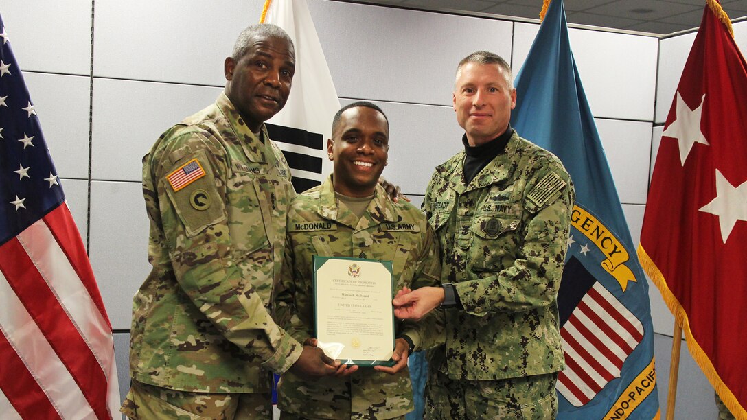 The Defense Logistics Agency Director and senior enlisted leader pose for photo after solder is promoted to sergeant first class.