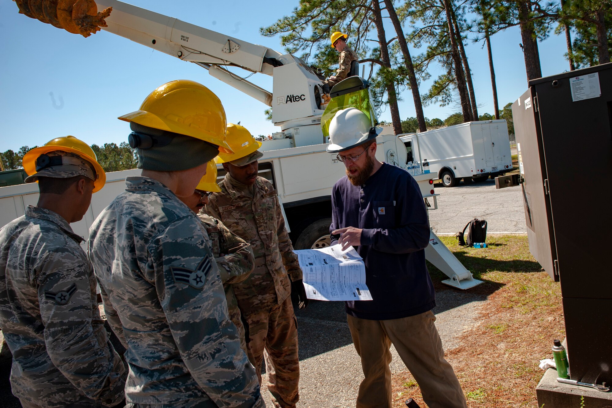 A photo of Airmen looking at a sheet.