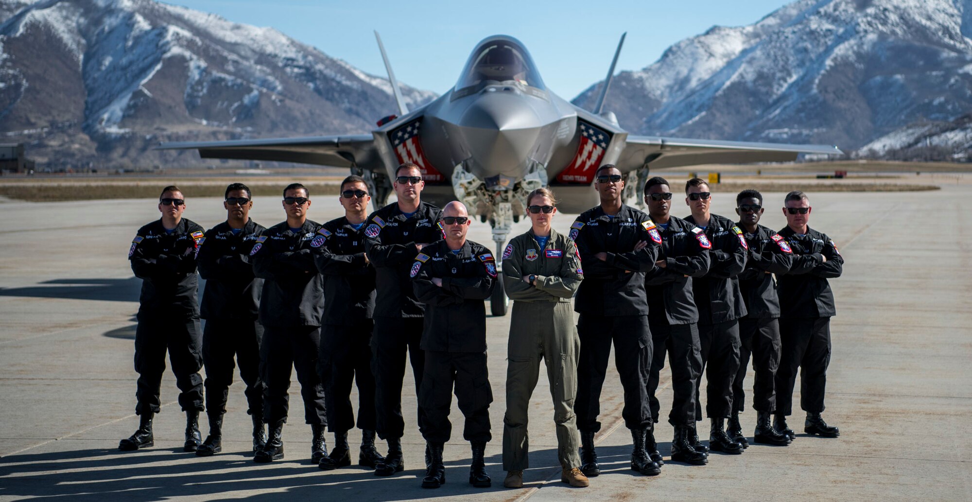 A F-35A Lightning II Demonstration Team group picture in front of an F-35A.