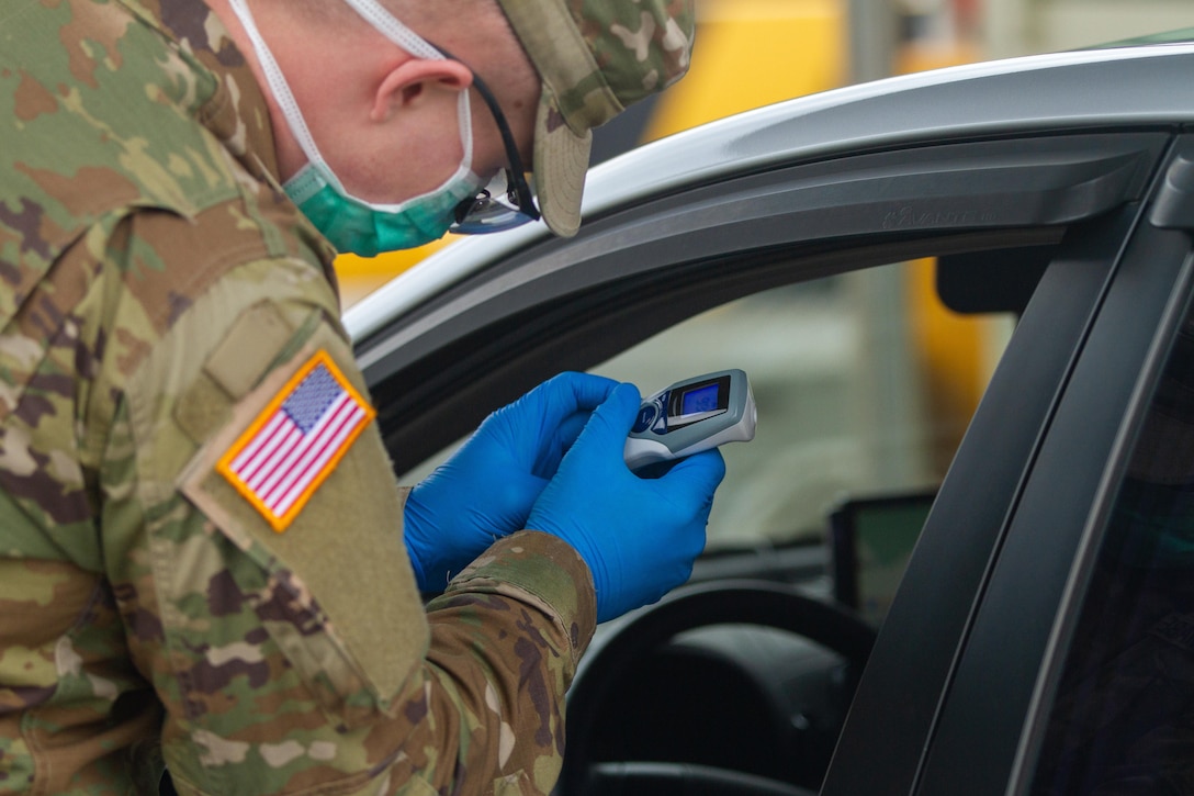 A soldier checks a thermometer reading.
