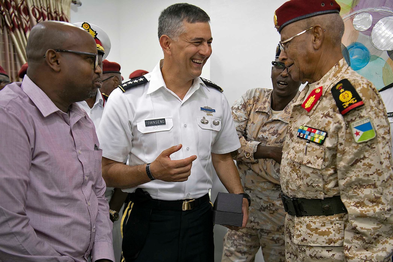 Two military men speak to one another.