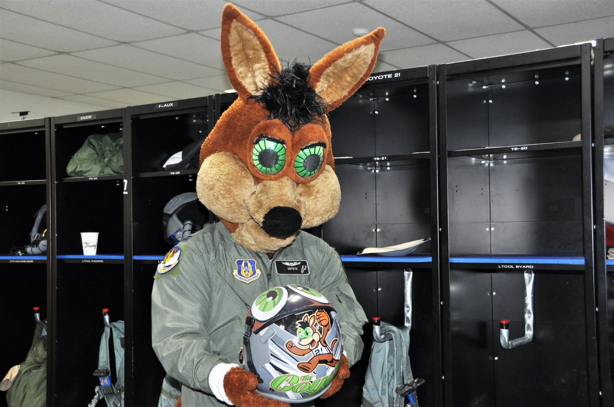 The Spurs Coyote checks out his customized helmet in the 559th Training Squadron locker room at Joint Base San Antonio-Randolph, Texas February 25 where Regular Air Force, Air Force Reserve, and civilian Airmen from the 340th Flying Training Group headquarters, 39th Flying Training Squadron T-6 Texan Flight, 12th Flying Training Wing Safety, 559th Flying Training Squadron T T-6 team, and 3rd Combat Camera Squadron (JBSA-Lackland) members, and the NBA San Antonio Spurs production crew worked to put the Coyote through the pilot training process. Video footage will be used for a Spurs Military Appreciation video to be shown during the March 10 game.  (U.S. Air Force photo by Janis El Shabazz)