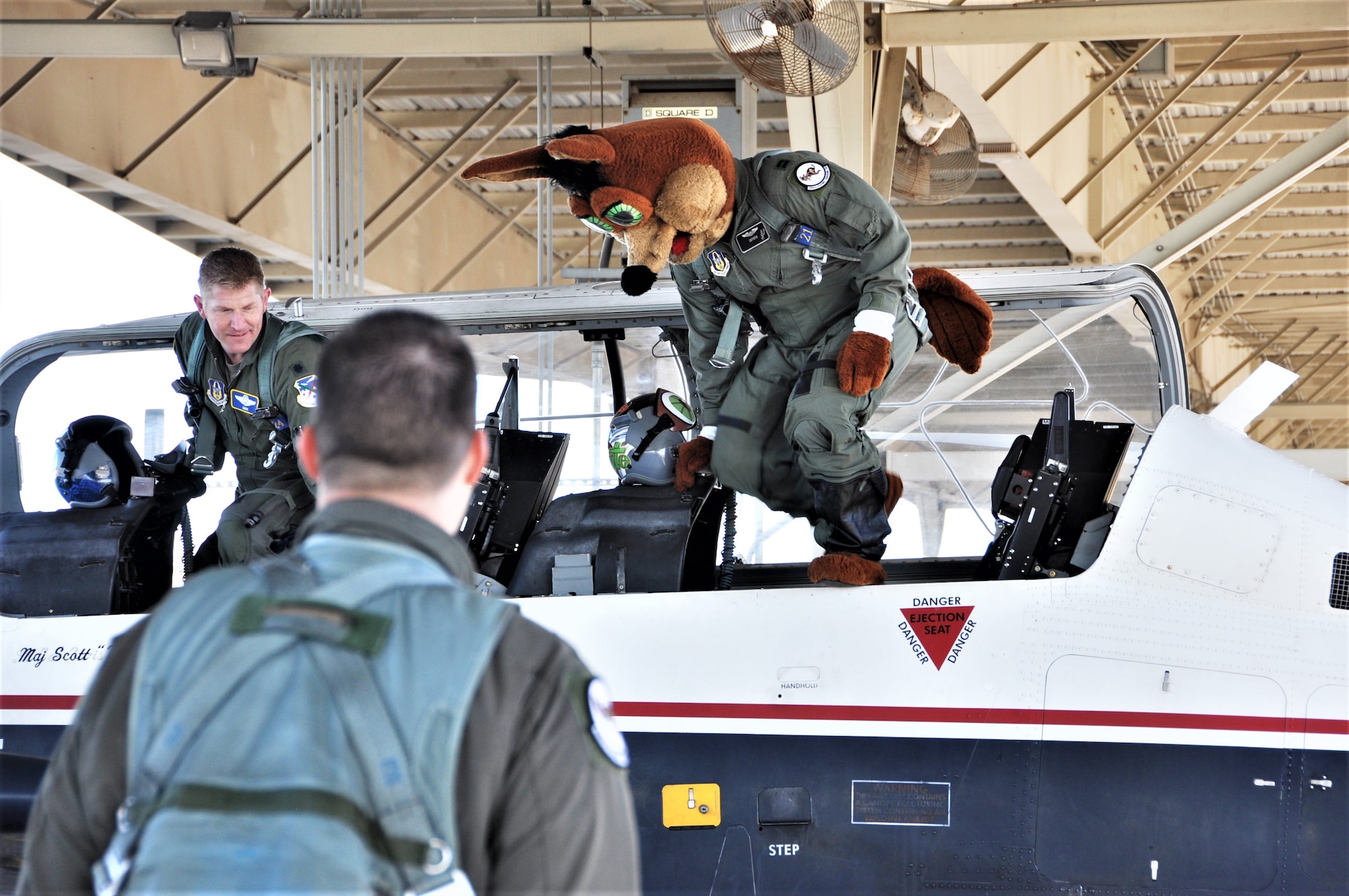 The Spurs Coyote and 340th Flying Training Group instructor pilot– Lt. Col. Mark Pasierb – exit the aircraft after the Coyote’s simulated flight at Joint Base San Antonio-Randolph, Texas February 25 where Regular Air Force, Air Force Reserve, and civilian Airmen from the 340th Flying Training Group headquarters, 39th Flying Training Squadron T-6 Texan Flight, 12th Flying Training Wing Safety, 559th Flying Training Squadron T-6 team, and 3rd Combat Camera Squadron (JBSA-Lackland) members, and the NBA San Antonio Spurs production crew worked to put the Coyote through the pilot training process. Video footage will be used for a Spurs Military Appreciation video to be shown during the March 10 game. (U.S. Air Force photo by Janis El Shabazz)